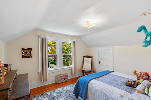 bedroom with wood-type flooring and vaulted ceiling