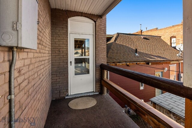 view of exterior entry with a balcony