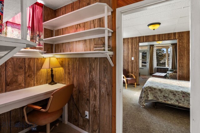 bedroom featuring wood walls and carpet