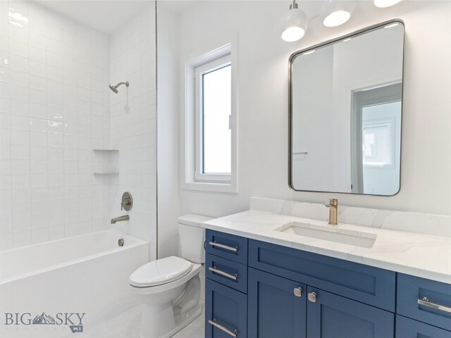 full bathroom with vanity, tiled shower / bath combo, and toilet