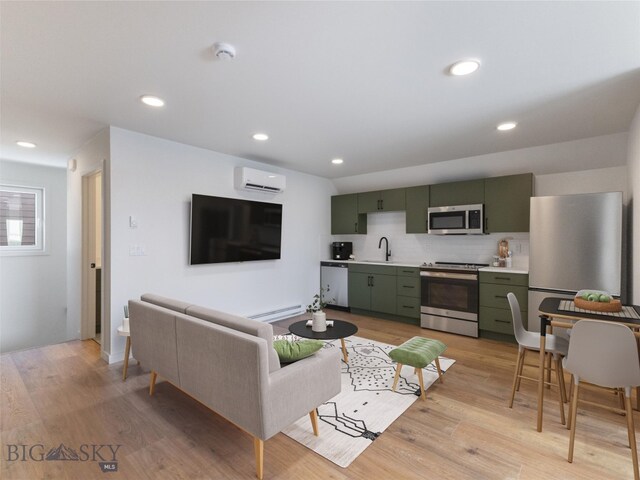 living room featuring light wood-type flooring, sink, baseboard heating, and a wall mounted AC