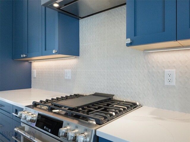 kitchen featuring tasteful backsplash, blue cabinetry, stainless steel gas range oven, and ventilation hood