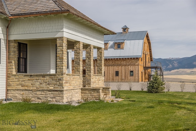 view of side of property with a mountain view and a yard