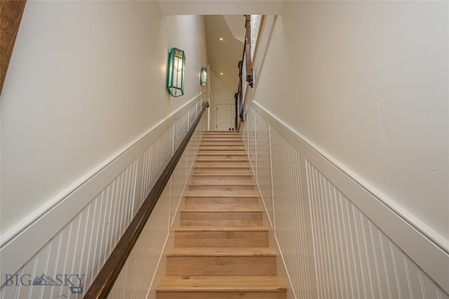 stairs featuring hardwood / wood-style floors