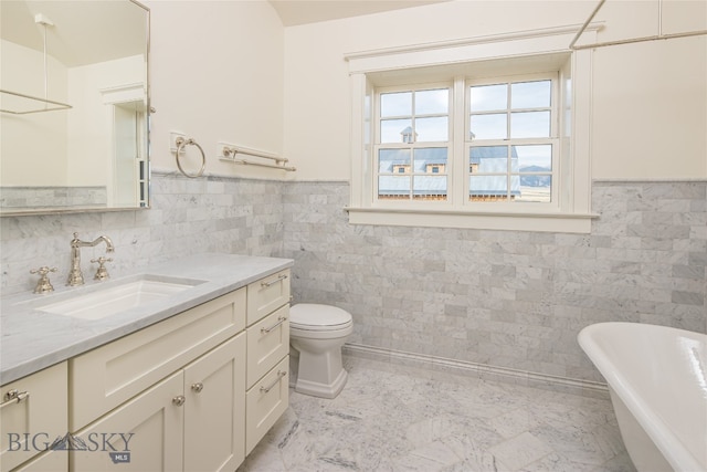 bathroom featuring tile walls, vanity, a tub to relax in, and toilet