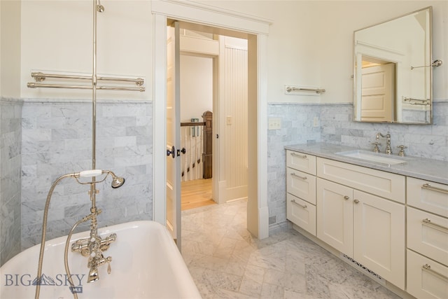 bathroom featuring a tub, vanity, and tile walls