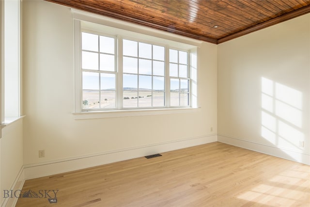 empty room featuring light hardwood / wood-style floors, crown molding, and wood ceiling