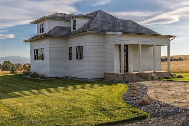 view of property exterior with a yard and a patio area