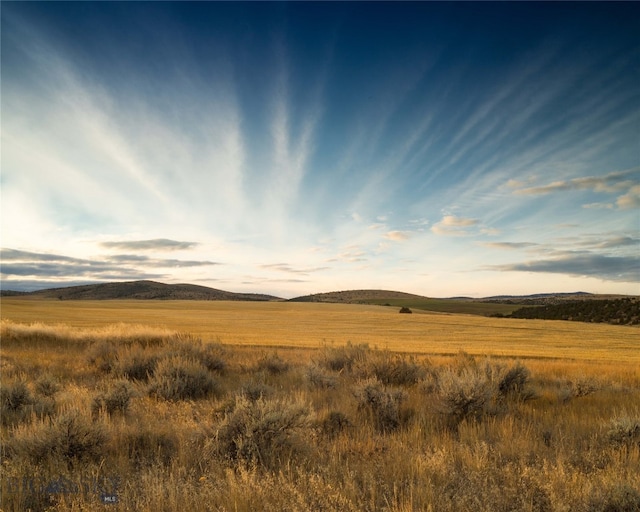 nature at dusk featuring a mountain view and a rural view