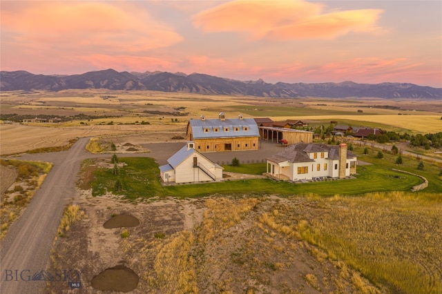 aerial view at dusk featuring a mountain view