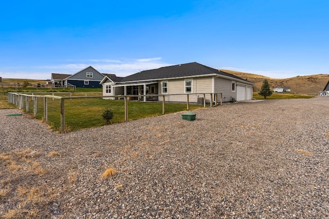 single story home featuring a sunroom, a mountain view, and a garage