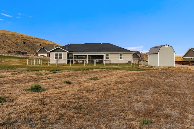 back of property with a storage shed