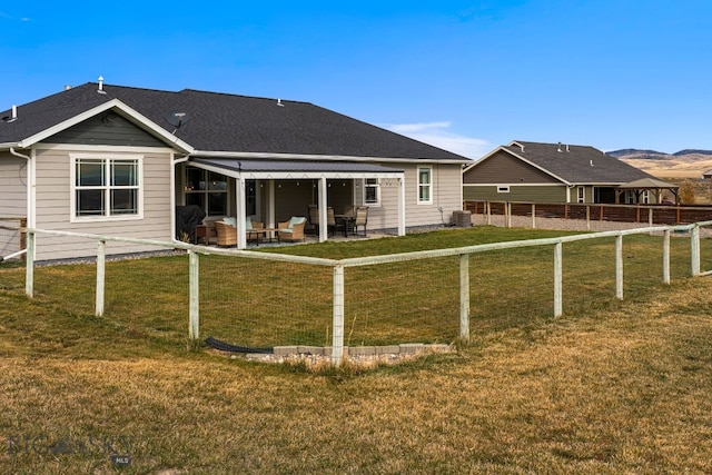 back of property with a lawn, a patio, and central AC