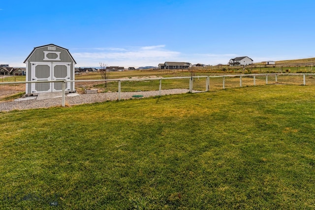 view of yard featuring a rural view and a storage unit