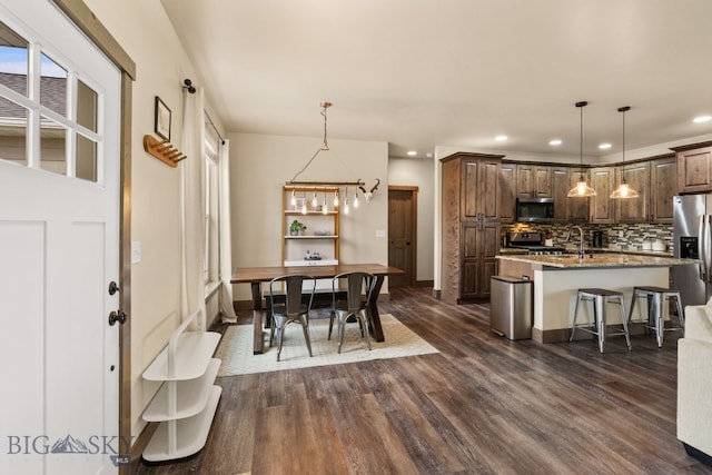 dining space featuring a chandelier, dark wood-type flooring, and sink