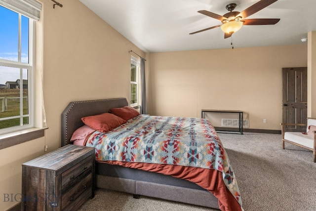 carpeted bedroom featuring ceiling fan and multiple windows