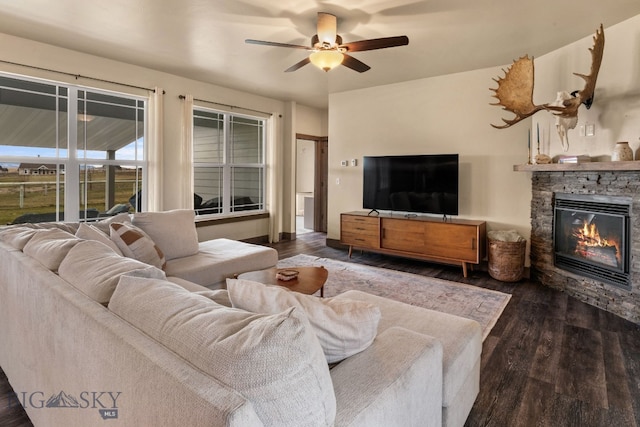 living room featuring a fireplace, ceiling fan, and dark wood-type flooring