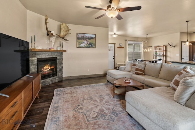 living room with dark hardwood / wood-style floors, ceiling fan, and a fireplace