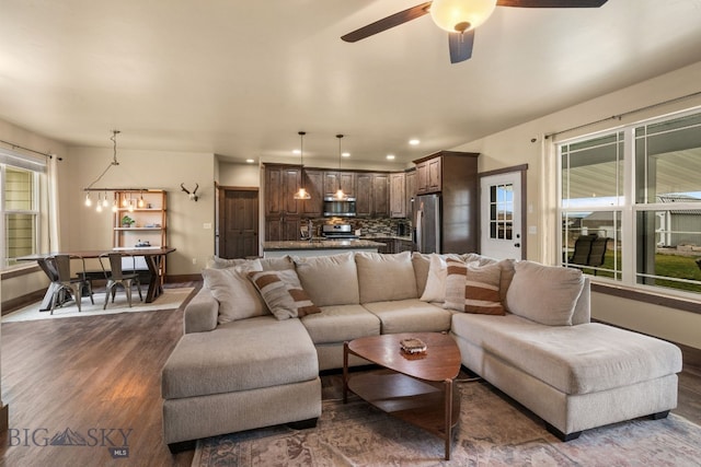 living room featuring ceiling fan and dark wood-type flooring