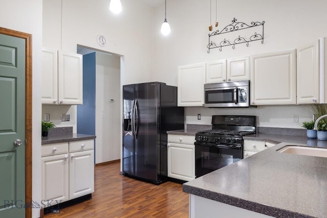 kitchen featuring pendant lighting, white cabinets, sink, and black appliances