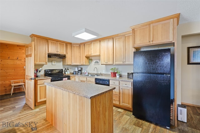 kitchen featuring sink, black appliances, light brown cabinets, a center island, and light wood-type flooring