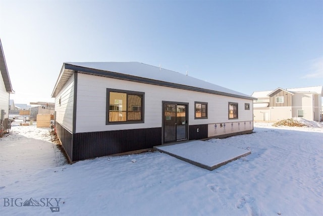 view of snow covered rear of property