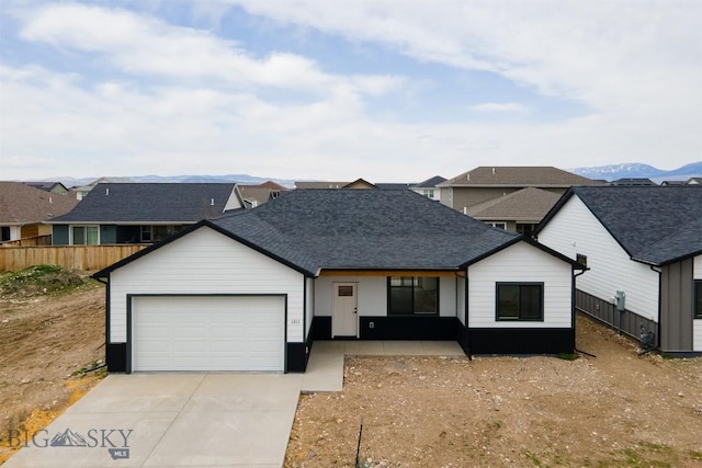 1511 Pistolero Way, Belgrade, MT 59714 - view of front facade with an attached garage, driveway, fence, a shingled roof, and covered porch