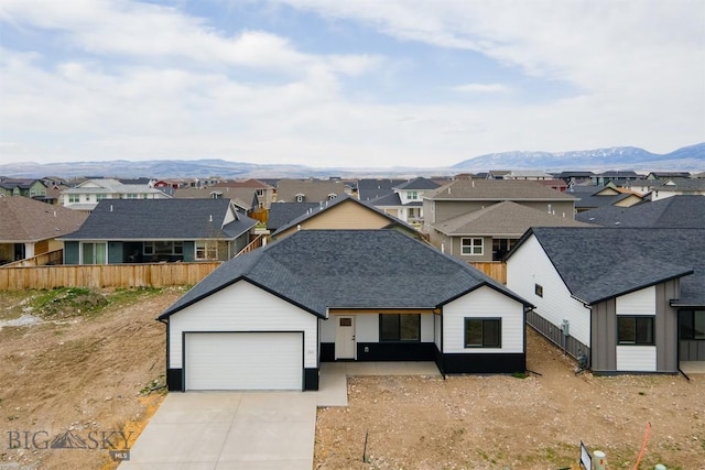1511 Pistolero Way, Belgrade, MT 59714 - view of front facade with a residential view, driveway, fence, and an attached garage