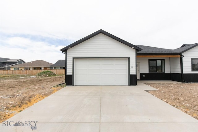 1511 Pistolero Way, Belgrade, MT 59714 - view of front facade featuring driveway, an attached garage, and fence