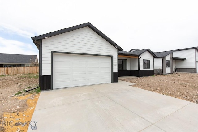 1511 Pistolero Way, Belgrade, MT 59714 - view of front of home featuring concrete driveway, fence, and an attached garage
