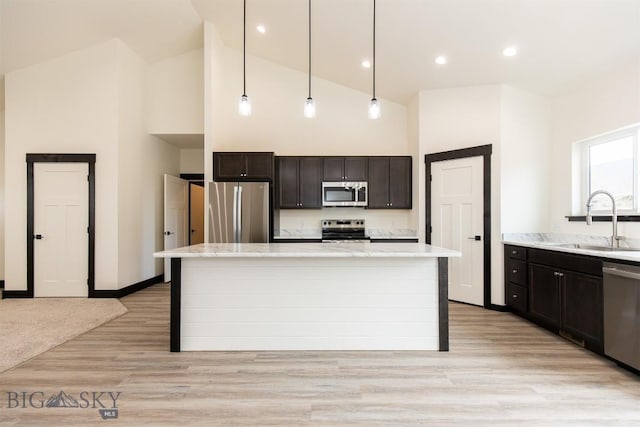 1511 Pistolero Way, Belgrade, MT 59714 - kitchen with appliances with stainless steel finishes, a sink, high vaulted ceiling, a kitchen island, and decorative light fixtures