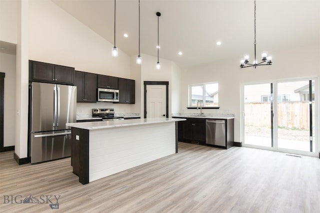 1511 Pistolero Way, Belgrade, MT 59714 - kitchen with appliances with stainless steel finishes, a sink, a chandelier, light wood finished floors, and pendant lighting