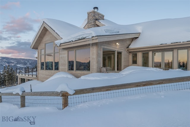 view of snow covered rear of property