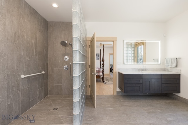 bathroom with vanity, a tile shower, and wood-type flooring