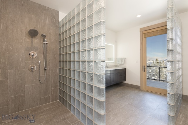 bathroom featuring tiled shower and vanity