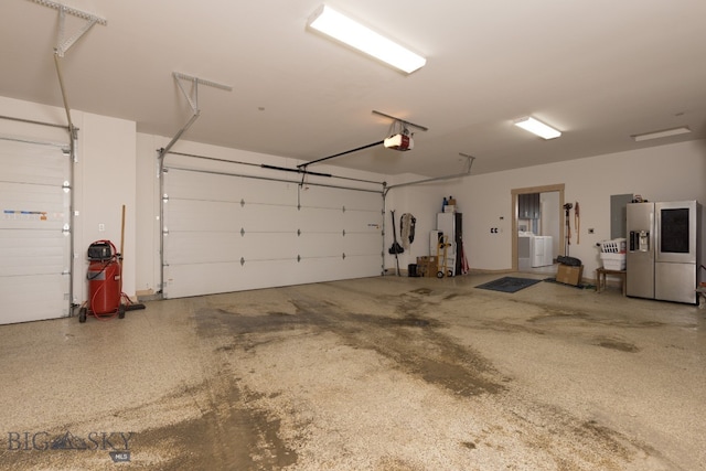 garage featuring a garage door opener, stainless steel fridge with ice dispenser, and washer / clothes dryer