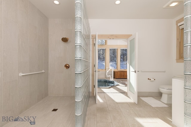 bathroom with tiled shower and toilet