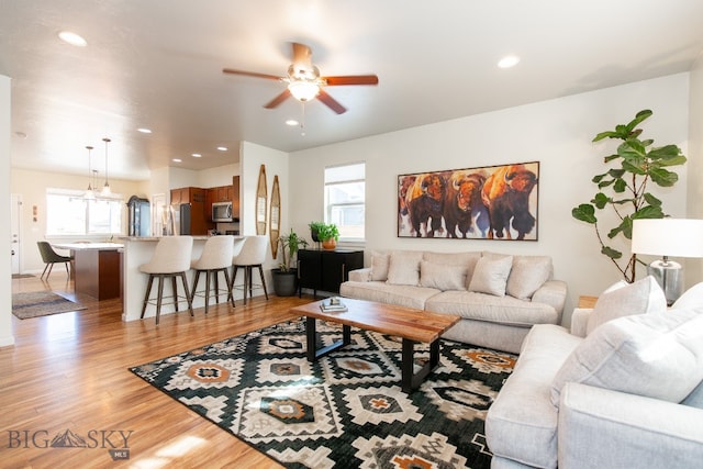 living room featuring light wood-type flooring, a wealth of natural light, and ceiling fan