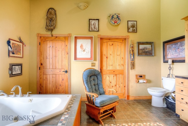 bathroom with tiled bath, tile patterned flooring, and toilet