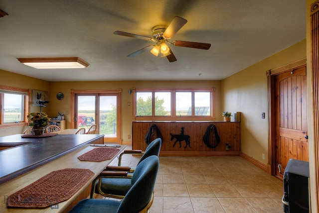 home office with a wealth of natural light, ceiling fan, a textured ceiling, and light tile patterned flooring