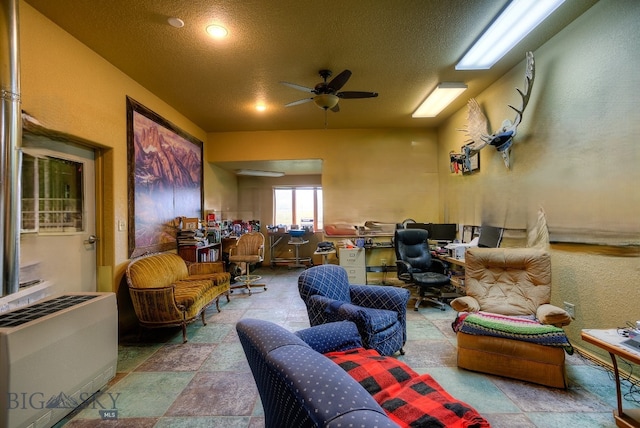 home theater room with heating unit, a textured ceiling, and ceiling fan