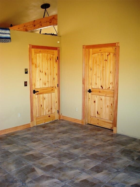 spare room with beam ceiling and high vaulted ceiling