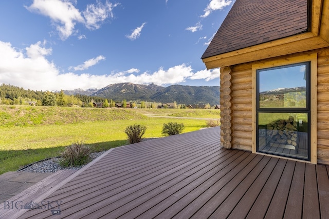 deck featuring a mountain view, a yard, and a rural view