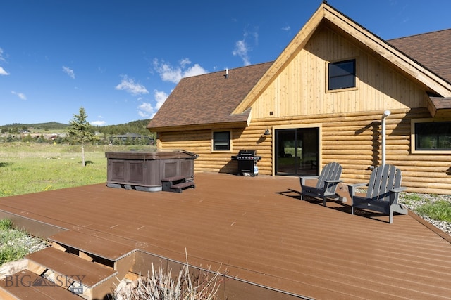 wooden deck featuring a hot tub and a grill