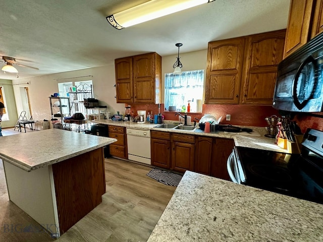 kitchen featuring sink, white dishwasher, decorative light fixtures, light wood-type flooring, and electric range