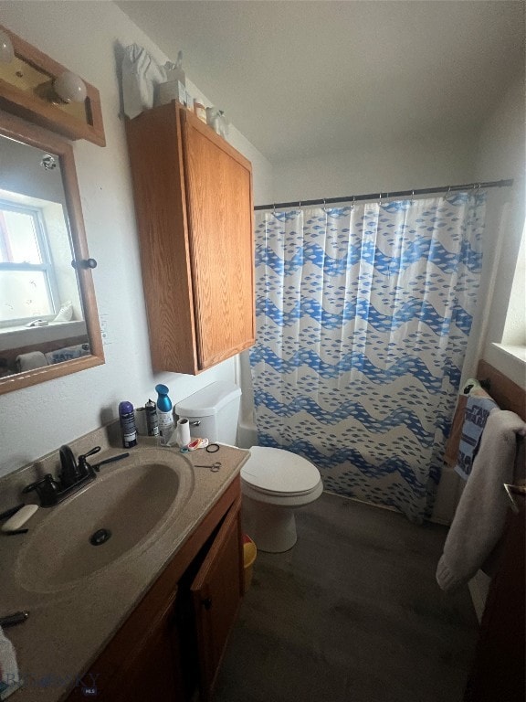 bathroom featuring hardwood / wood-style floors, walk in shower, vanity, and toilet