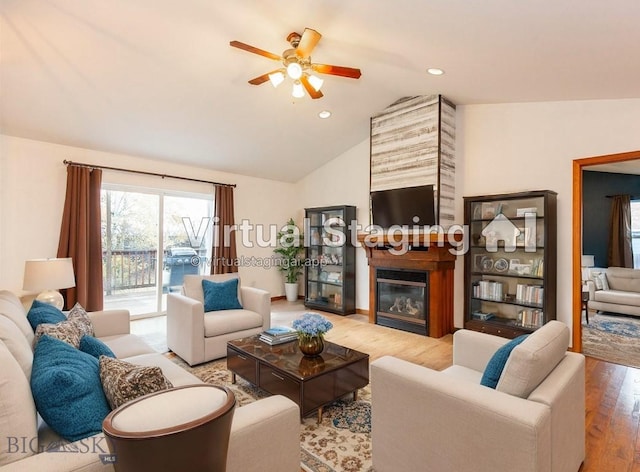 living room with ceiling fan, hardwood / wood-style floors, and vaulted ceiling