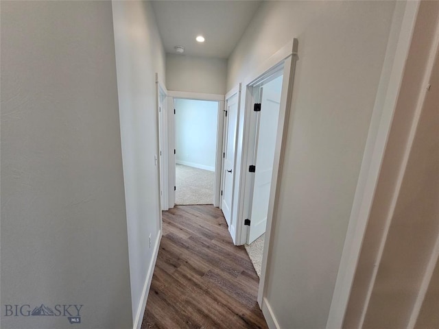 hallway with recessed lighting, wood finished floors, and baseboards