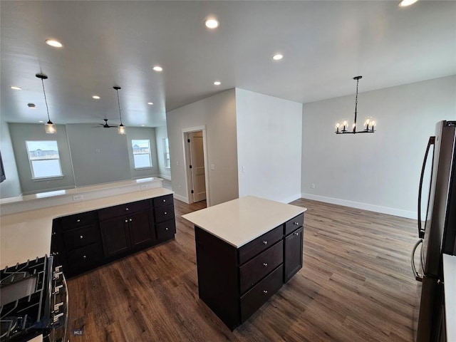 kitchen featuring pendant lighting, light countertops, freestanding refrigerator, open floor plan, and a kitchen island