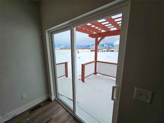 doorway featuring visible vents, wood finished floors, a mountain view, and baseboards